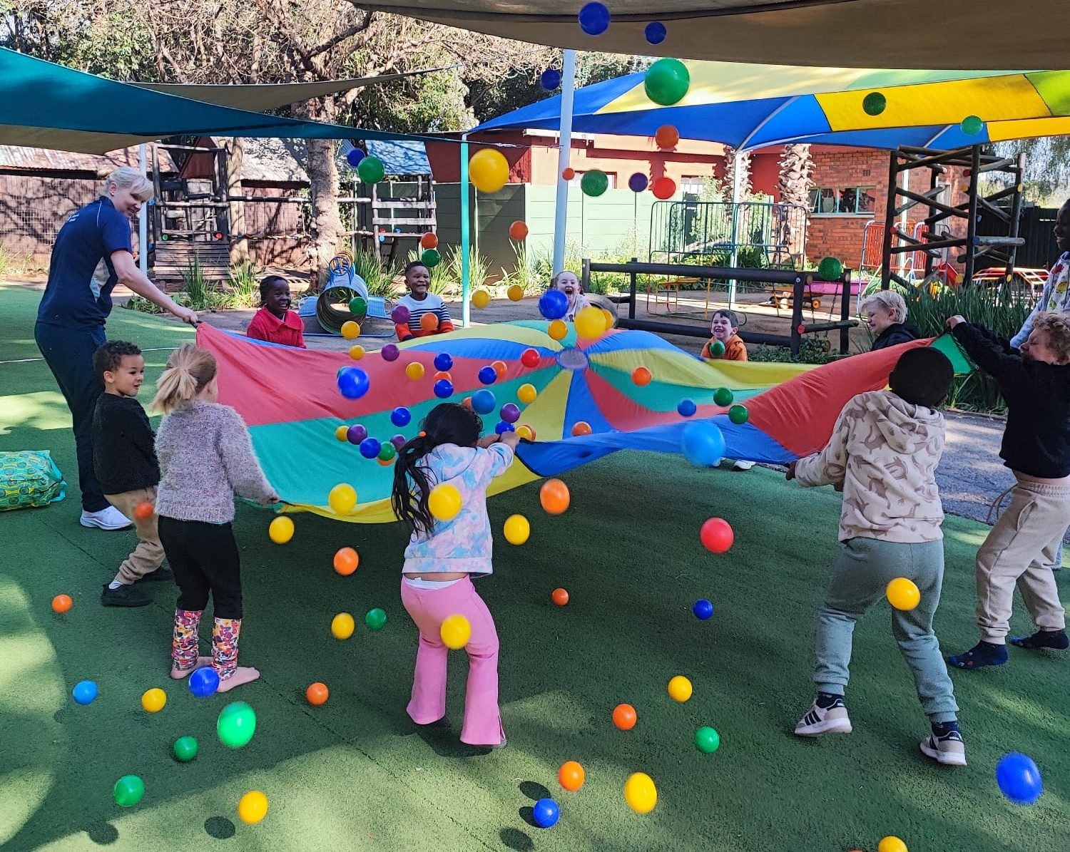 Children playing a parachute game together in the garden